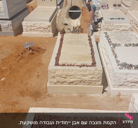 מצבות בבית קברות עם אנשים ברקע